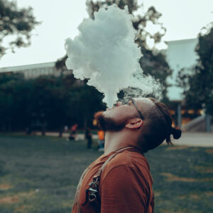 Man vaping, blowing smoke